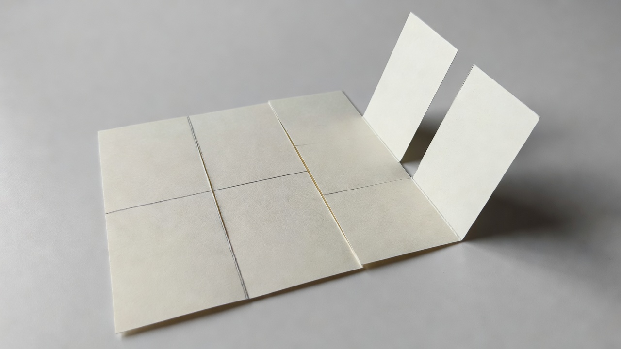 A folded paper base with two parallel cuts marked beside an opened pop-up test